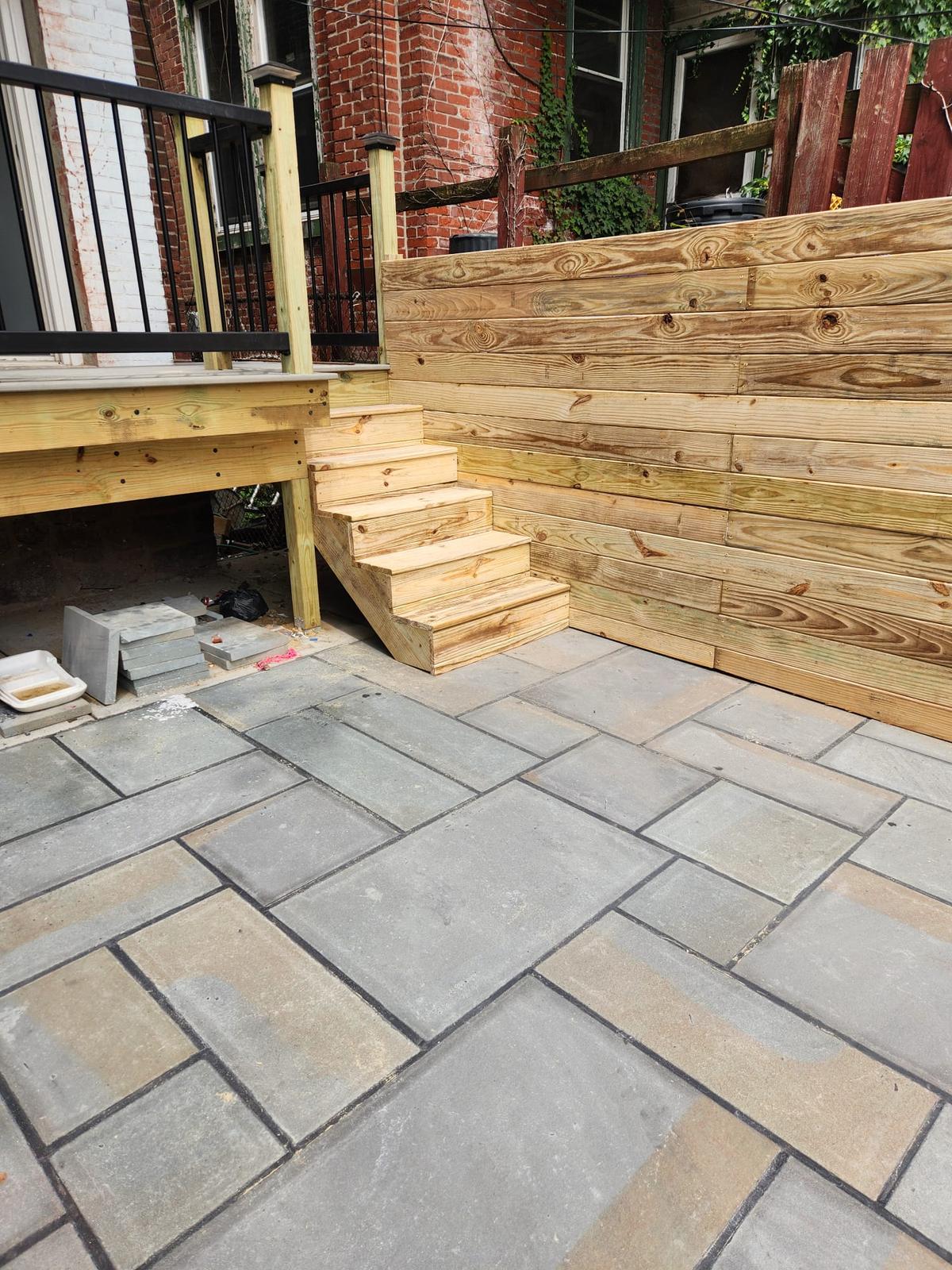 Bluestone pavers meeting the deck steps and horizontal wood fence
